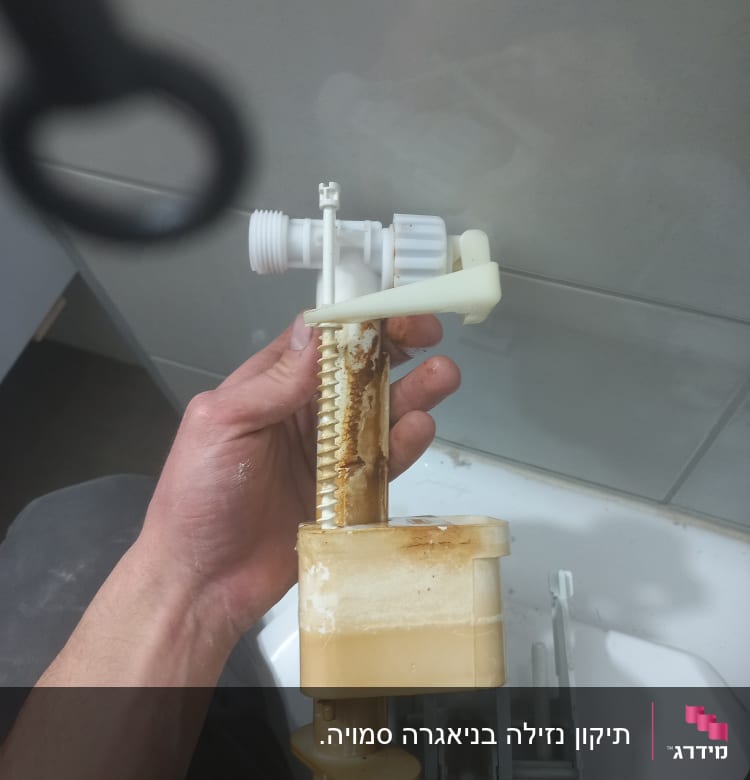 יד מחזיקה חלק פלסטיק של אסלה עם חלודה